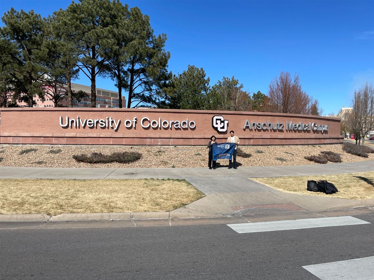 Participants with Yachay Tech flag at CU Anschutz sign