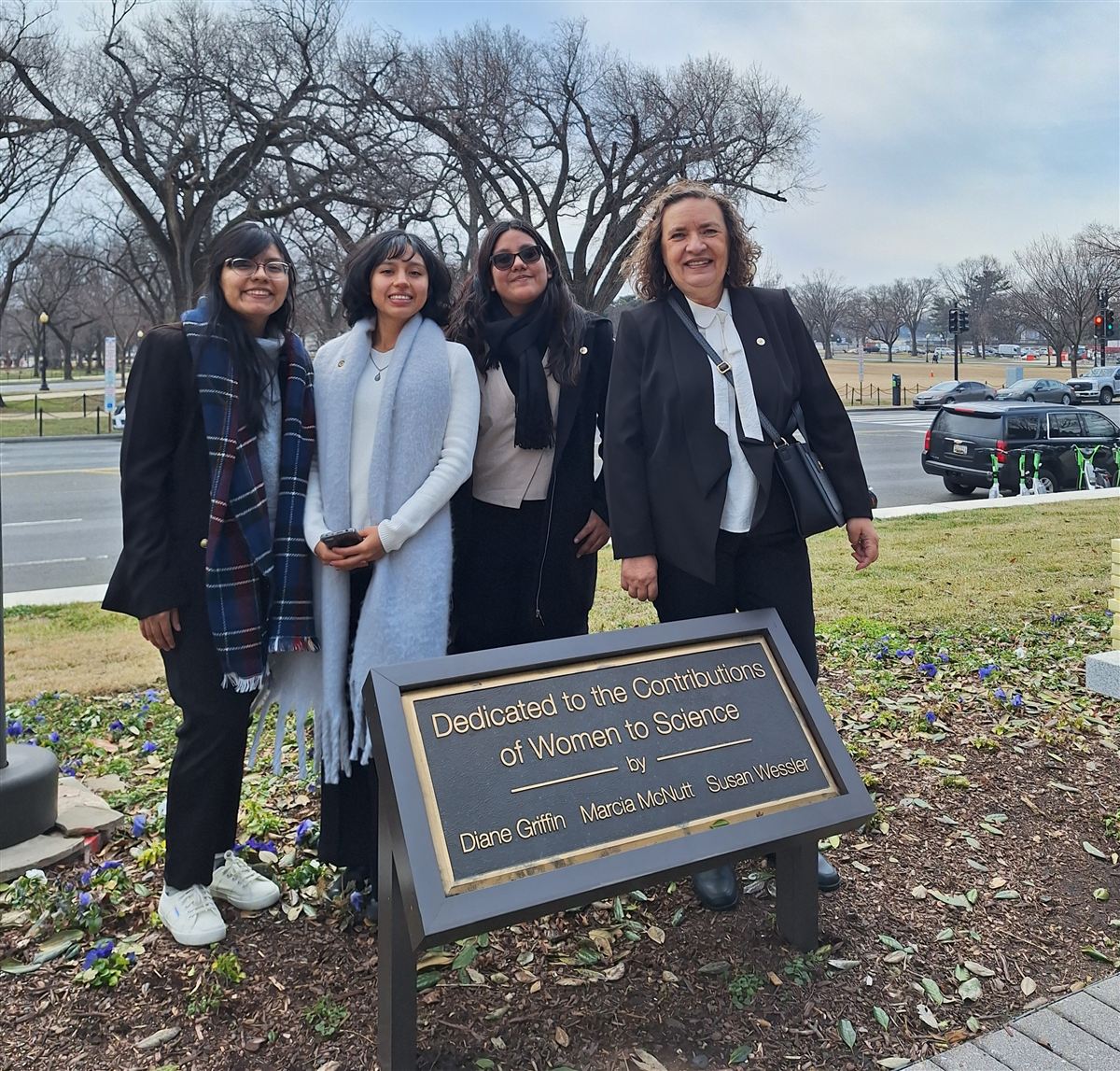 Women participants at science plaque, D.C.